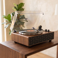 Platine vinyle Cadence posée sur une console en noyer dans un salon lumineux