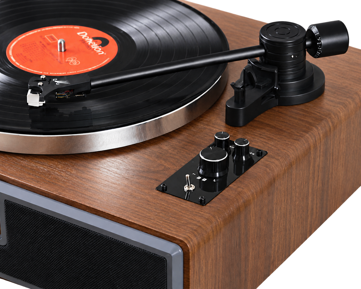 Platine vinyle Bluetooth Héritage à finition bois, détail du bras de lecture, du plateau et des commandes.