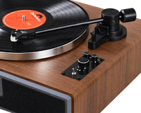 Platine vinyle Bluetooth Héritage à finition bois, détail du bras de lecture, du plateau et des commandes.