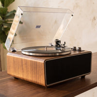 Platine vinyle Studio posée sur une console en noyer près d'une fenêtre